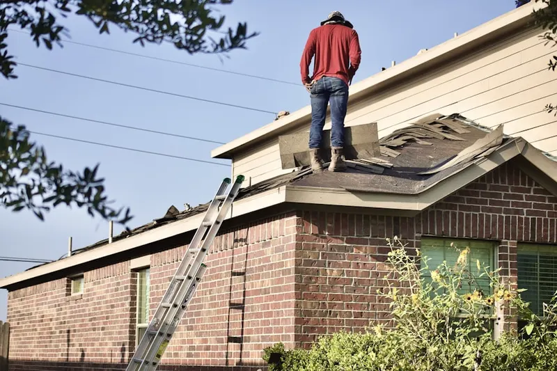 Professional roofer working on a residential roof in Double R Blvd